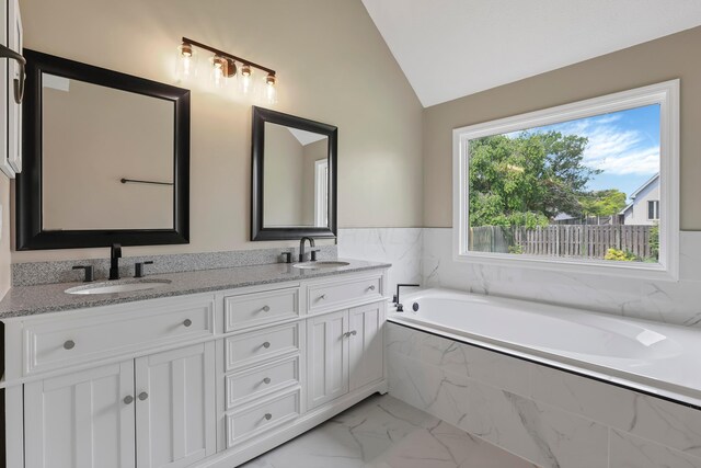 4583 Hunting Creek Dr, Grove City, OH 43123 - bathroom with marble look tiles, lofted ceiling, double vanity, and a bath