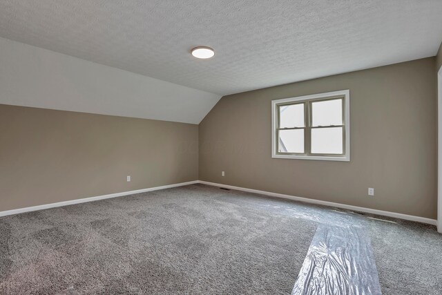 4583 Hunting Creek Dr, Grove City, OH 43123 - additional living space with carpet, baseboards, vaulted ceiling, and a textured ceiling