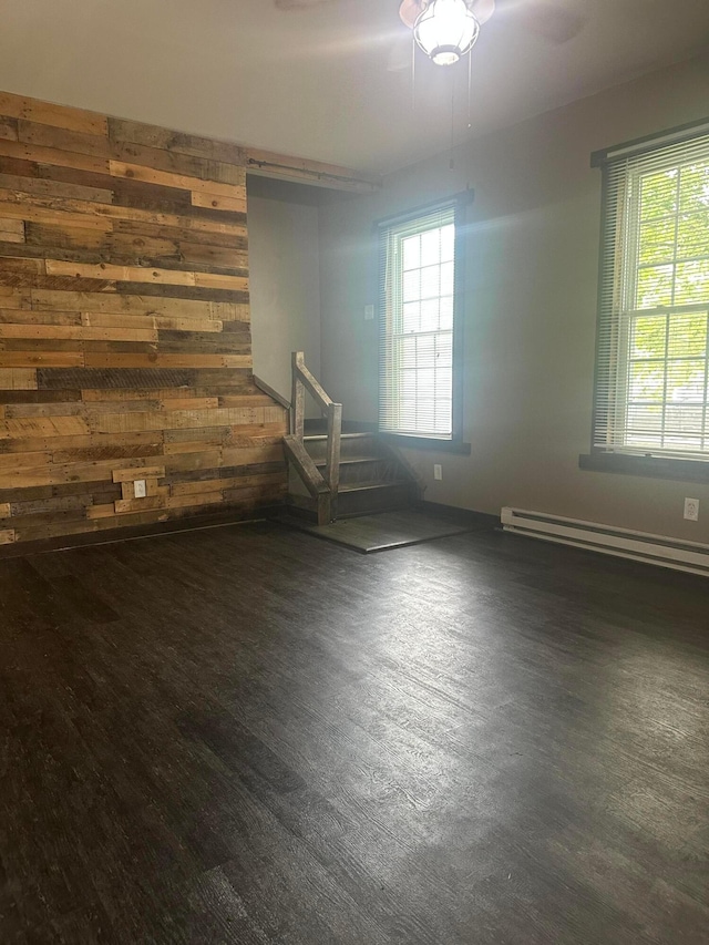 287 W Columbus St, Mount Sterling, OH 43143 - empty room featuring a baseboard heating unit, plenty of natural light, wood walls, and wood finished floors