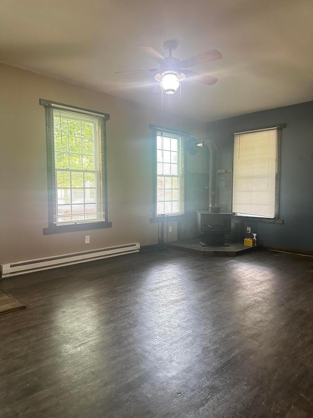 287 W Columbus St, Mount Sterling, OH 43143 - spare room with a wood stove, a baseboard radiator, ceiling fan, and dark wood-style flooring