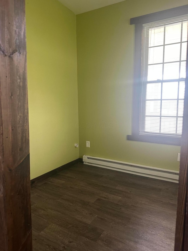 287 W Columbus St, Mount Sterling, OH 43143 - empty room with baseboard heating, dark wood finished floors, and baseboards