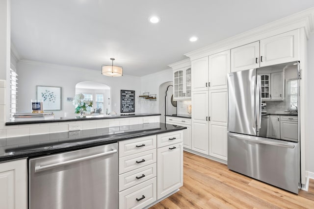 1572 Barrington Rd, Upper Arlington, OH 43221 - kitchen with appliances with stainless steel finishes, dark countertops, arched walkways, decorative backsplash, and crown molding