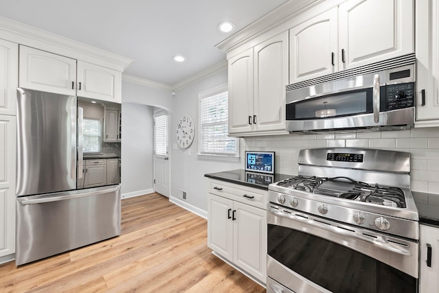 1572 Barrington Rd, Upper Arlington, OH 43221 - kitchen featuring appliances with stainless steel finishes, dark countertops, ornamental molding, baseboards, and white cabinets