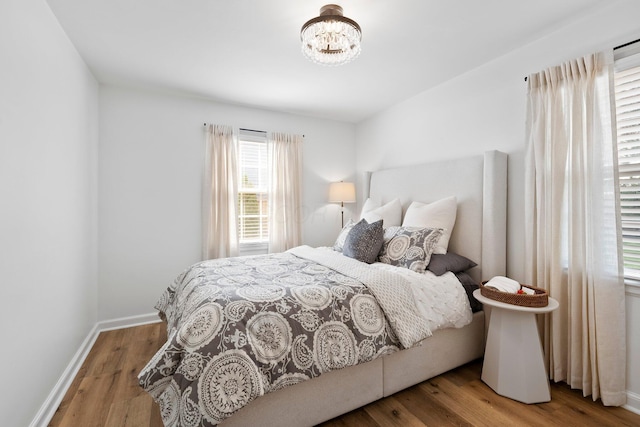 1572 Barrington Rd, Upper Arlington, OH 43221 - bedroom featuring a chandelier, wood finished floors, and baseboards