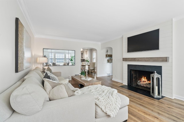 1572 Barrington Rd, Upper Arlington, OH 43221 - living room featuring arched walkways, ornamental molding, wood finished floors, a fireplace, and baseboards