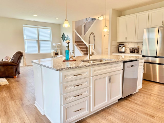 3895 Brody Dr, Grove City, OH 43123 - kitchen with appliances with stainless steel finishes, a sink, light wood-style flooring, a center island with sink, and recessed lighting