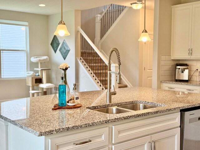 3895 Brody Dr, Grove City, OH 43123 - kitchen featuring a sink, stainless steel dishwasher, decorative backsplash, white cabinetry, and light stone countertops