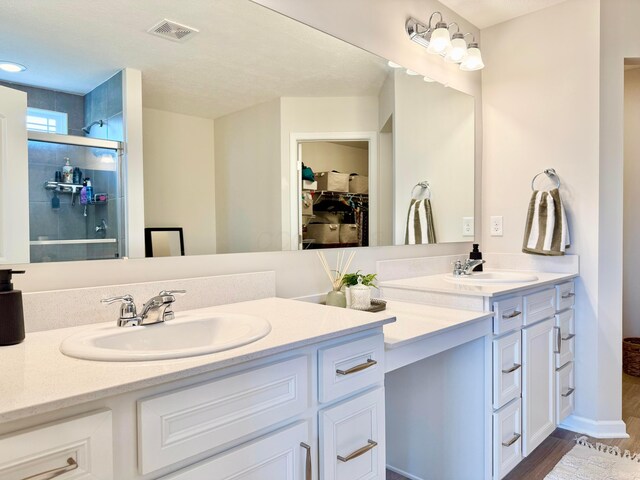 3895 Brody Dr, Grove City, OH 43123 - full bathroom with double vanity, a spacious closet, tiled shower, and wood finished floors