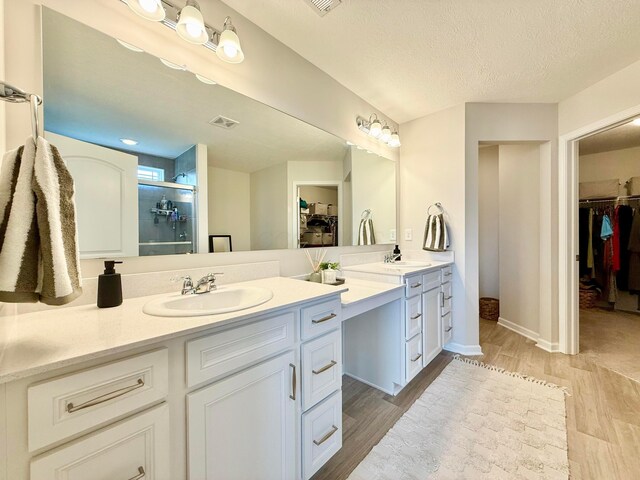 3895 Brody Dr, Grove City, OH 43123 - full bathroom featuring a spacious closet, double vanity, wood finished floors, and a textured ceiling