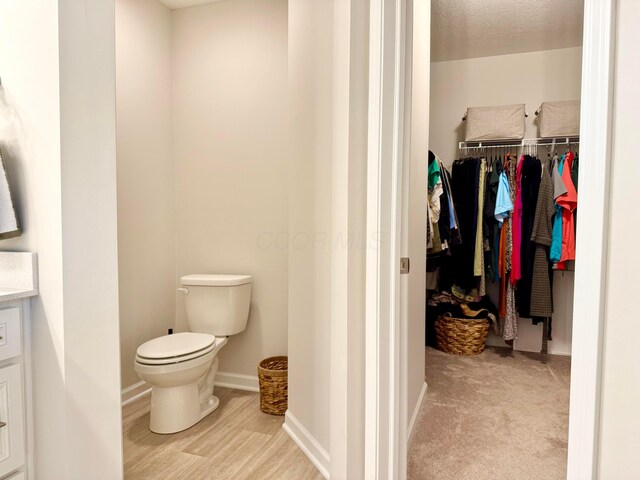 3895 Brody Dr, Grove City, OH 43123 - bathroom with toilet, wood finished floors, a walk in closet, and baseboards