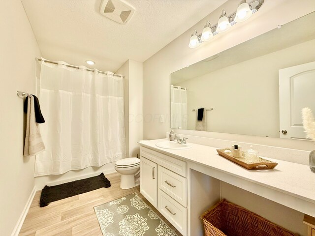 3895 Brody Dr, Grove City, OH 43123 - bathroom featuring vanity, toilet, wood finished floors, a textured ceiling, and shower / bath combo
