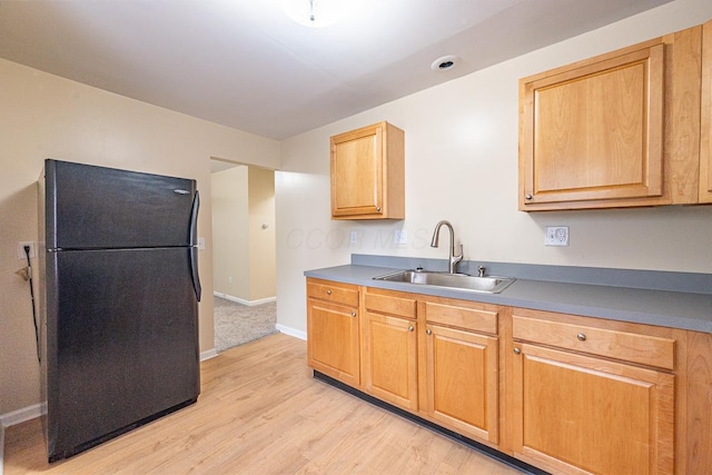 1121 Oakwood Ave, Columbus, OH 43206 - kitchen featuring freestanding refrigerator, a sink, light wood-style floors, and baseboards