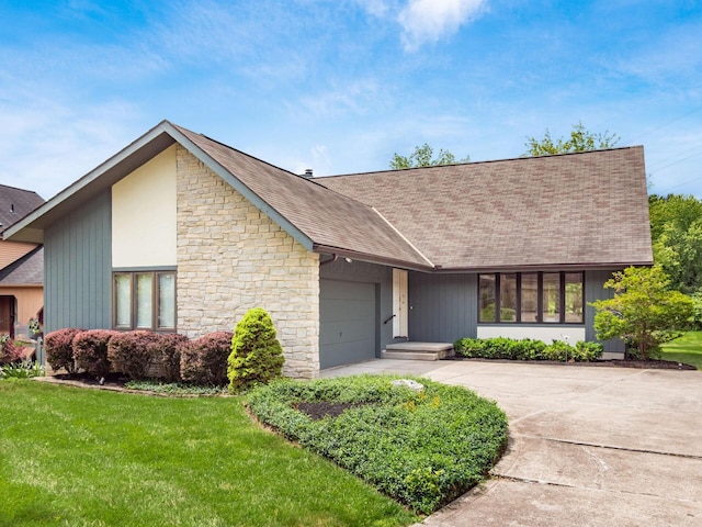5434 Flat Head Ct, Columbus, OH 43230 - view of front of house with a garage, driveway, roof with shingles, stone siding, and a front lawn