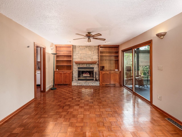 5434 Flat Head Ct, Columbus, OH 43230 - unfurnished living room featuring a textured ceiling, baseboards, a ceiling fan, a fireplace, and built in shelves