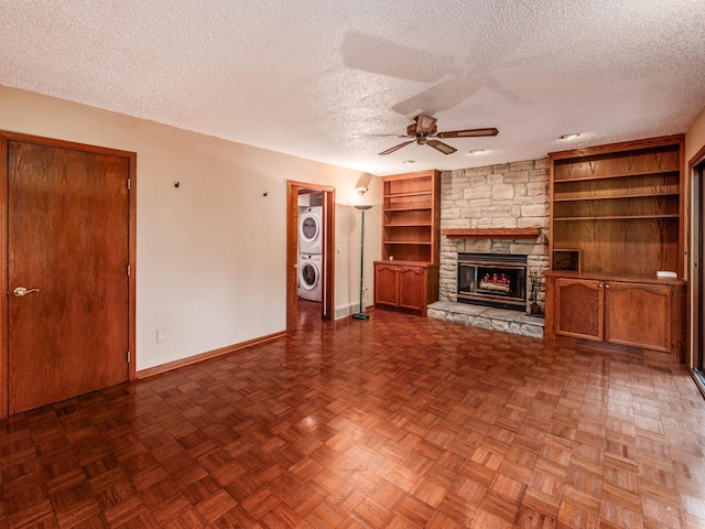 5434 Flat Head Ct, Columbus, OH 43230 - unfurnished living room with stacked washer / drying machine, a ceiling fan, baseboards, a fireplace, and a textured ceiling
