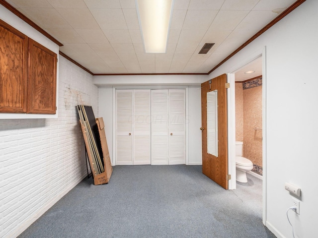 5434 Flat Head Ct, Columbus, OH 43230 - unfurnished bedroom featuring ornamental molding, carpet flooring, brick wall, a closet, and ensuite bathroom