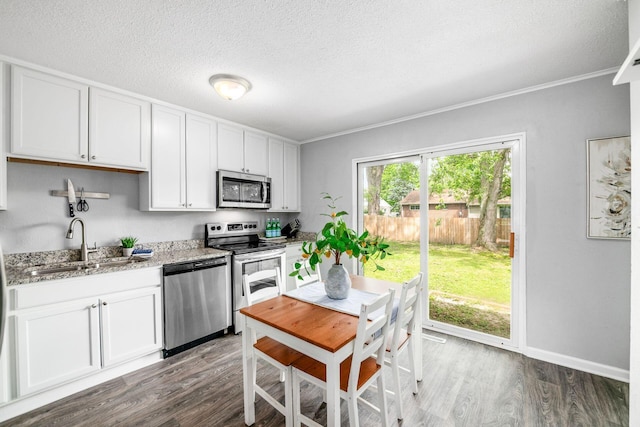 1058 Erickson Ave, Columbus, OH 43227 - kitchen featuring appliances with stainless steel finishes, a sink, dark wood finished floors, a textured ceiling, and white cabinets