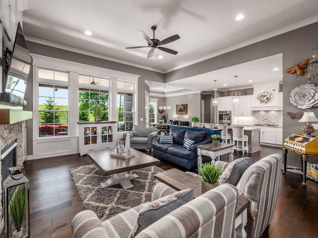 2235 Forestview Ln, Delaware, OH 43015 - living area featuring a ceiling fan, dark wood-style floors, ornamental molding, recessed lighting, and a stone fireplace