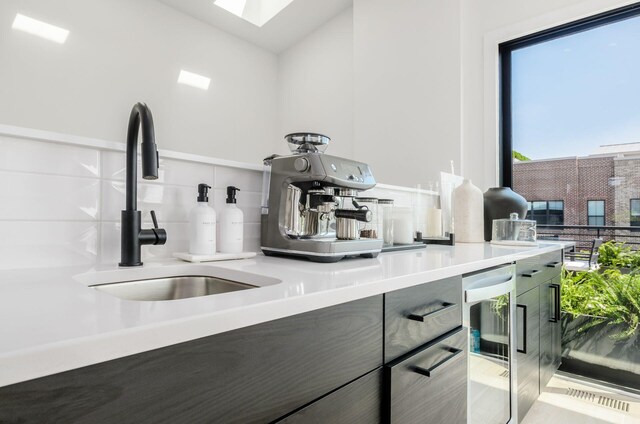 312 Cornelius St, Columbus, OH 43215 - kitchen with beverage cooler, light countertops, a skylight, and tasteful backsplash