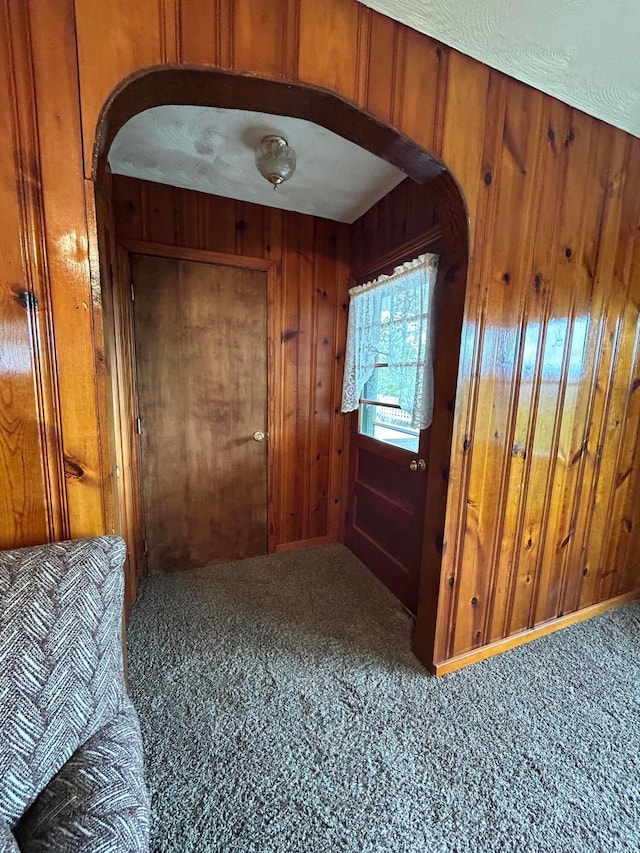 3049 Palace Heights Ln NW, Malta, OH 43758 - entryway featuring arched walkways, carpet, and wooden walls