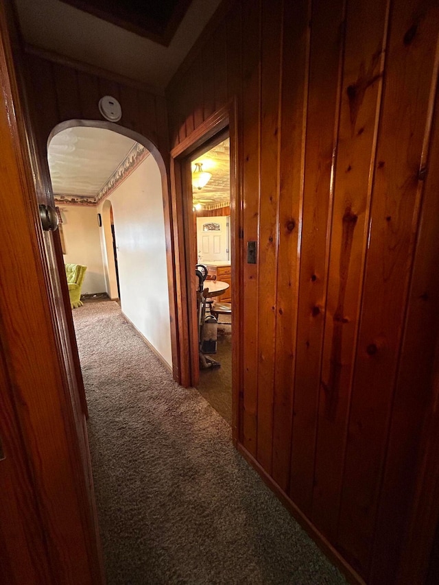 3049 Palace Heights Ln NW, Malta, OH 43758 - corridor featuring carpet flooring, arched walkways, and wood walls
