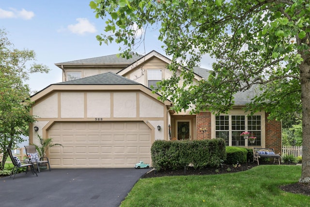 388 Slate Run Dr, Powell, OH 43065 - view of front of house with an attached garage, driveway, a shingled roof, stucco siding, and a front lawn