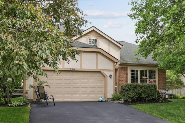 388 Slate Run Dr, Powell, OH 43065 - tudor house featuring stucco siding, a shingled roof, driveway, a garage, and a front lawn