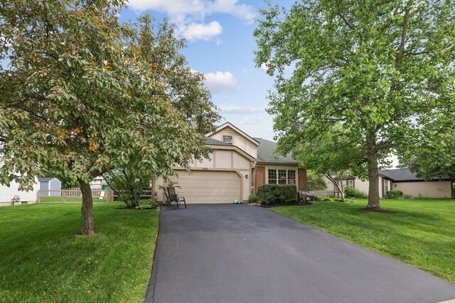 388 Slate Run Dr, Powell, OH 43065 - view of front of property with asphalt driveway, a garage, a front yard, and brick siding