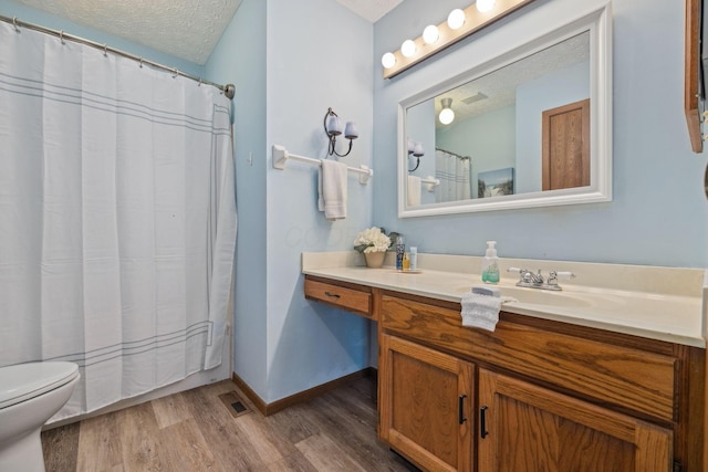 388 Slate Run Dr, Powell, OH 43065 - bathroom featuring wood finished floors, toilet, vanity, a textured ceiling, and baseboards