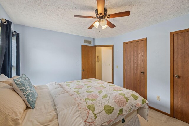 388 Slate Run Dr, Powell, OH 43065 - bedroom featuring light colored carpet, ceiling fan, baseboards, a textured ceiling, and two closets