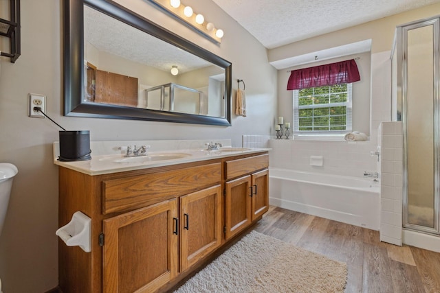 388 Slate Run Dr, Powell, OH 43065 - bathroom with wood finished floors, a shower stall, a textured ceiling, double vanity, and a bath