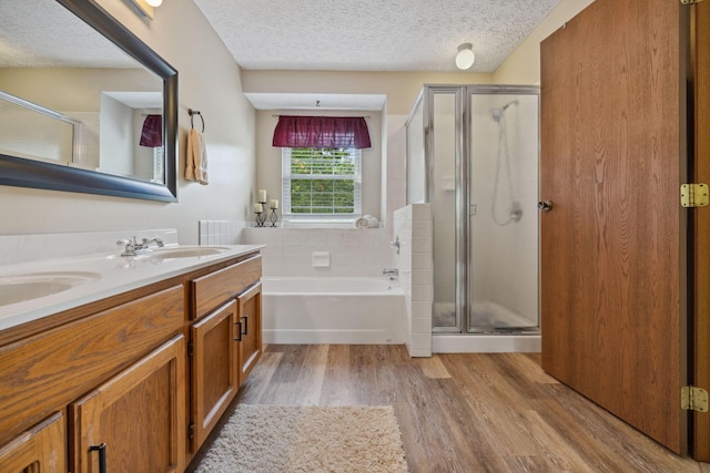 388 Slate Run Dr, Powell, OH 43065 - full bathroom with a garden tub, a shower stall, double vanity, wood finished floors, and a textured ceiling