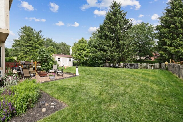 388 Slate Run Dr, Powell, OH 43065 - view of yard with a fire pit, a patio, an outdoor structure, and view of scattered trees