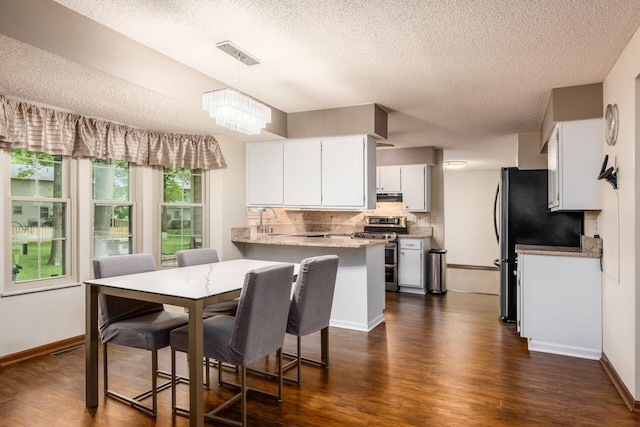 544 Waring Way, Columbus, OH 43213 - dining space featuring a textured ceiling, dark wood-type flooring, baseboards, and a chandelier