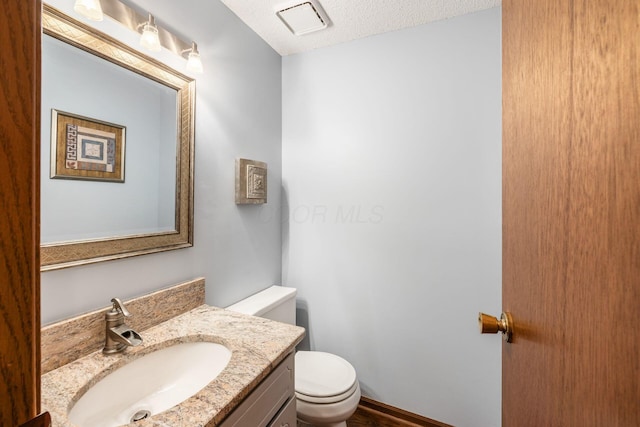 544 Waring Way, Columbus, OH 43213 - half bathroom featuring toilet, vanity, and a textured ceiling