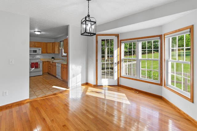 3040 Seney Rd Unit 912, Chillicothe, OH 45601 - unfurnished dining area featuring baseboards, a sink, light wood-style floors, and a textured ceiling