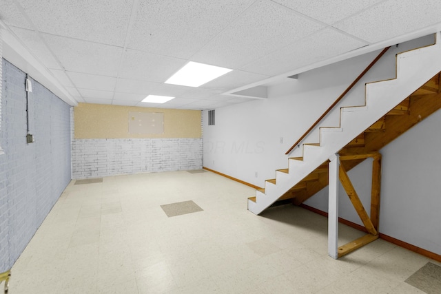 3040 Seney Rd Unit 912, Chillicothe, OH 45601 - finished basement with brick wall, a drop ceiling, tile patterned floors, stairs, and baseboards