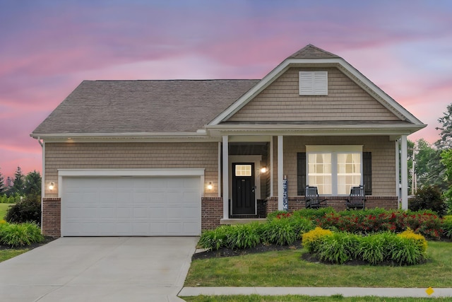 206 Rochdale Run, Delaware, OH 43015 - view of front of house with brick siding, covered porch, concrete driveway, an attached garage, and roof with shingles