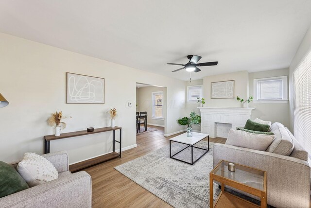 2509 Perdue Ave, Columbus, OH 43211 - living room with a ceiling fan, wood finished floors, baseboards, and a brick fireplace