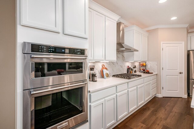 3446 Joberry Loop, Grove City, OH 43123 - kitchen with stainless steel appliances, wall chimney exhaust hood, ornamental molding, white cabinetry, and tasteful backsplash