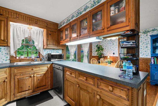 841 Township Highway 52, Nevada, OH 44849 - kitchen with wallpapered walls, a sink, stainless steel appliances, brown cabinetry, and glass insert cabinets