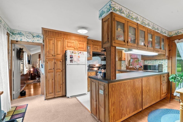 841 Township Highway 52, Nevada, OH 44849 - kitchen featuring freestanding refrigerator, stainless steel microwave, wallpapered walls, a peninsula, and glass insert cabinets