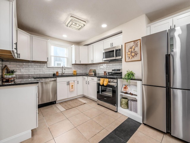 1156 S Champion Ave, Columbus, OH 43206 - kitchen with appliances with stainless steel finishes, dark countertops, backsplash, white cabinets, and recessed lighting