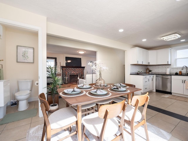 1156 S Champion Ave, Columbus, OH 43206 - dining room with a fireplace, light tile patterned flooring, recessed lighting, and a textured ceiling