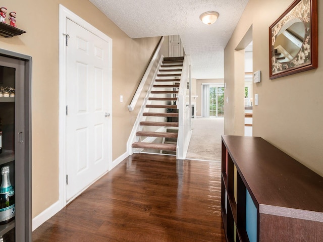 5678 Mango Ln Unit 104A, Hilliard, OH 43026 - foyer entrance featuring stairway, wood finished floors, a textured ceiling, and baseboards