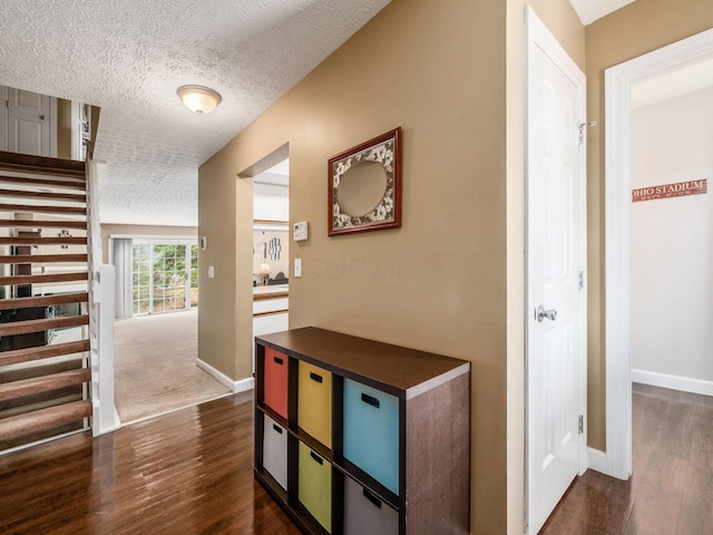 5678 Mango Ln Unit 104A, Hilliard, OH 43026 - hall featuring dark wood-style flooring, a textured ceiling, baseboards, and stairway