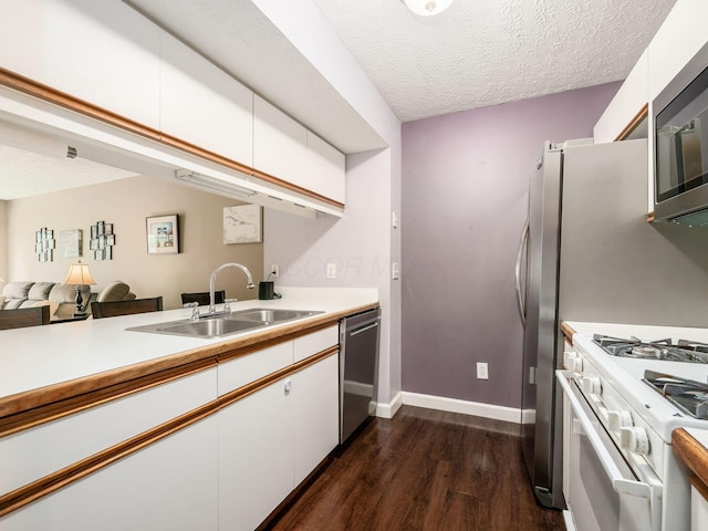 5678 Mango Ln Unit 104A, Hilliard, OH 43026 - kitchen with stainless steel appliances, a sink, dark wood finished floors, white cabinetry, and a textured ceiling