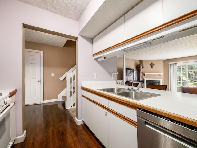 5678 Mango Ln Unit 104A, Hilliard, OH 43026 - kitchen with dishwasher, a fireplace, a textured ceiling, white cabinets, and dark wood-type flooring