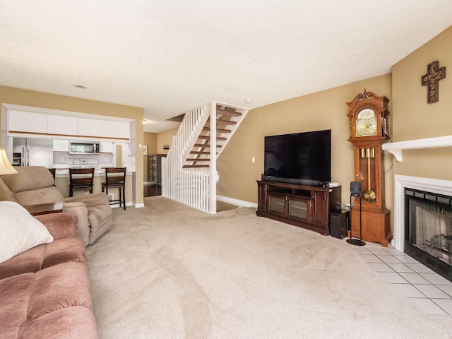 5678 Mango Ln Unit 104A, Hilliard, OH 43026 - carpeted living area with a fireplace with flush hearth, stairs, and baseboards