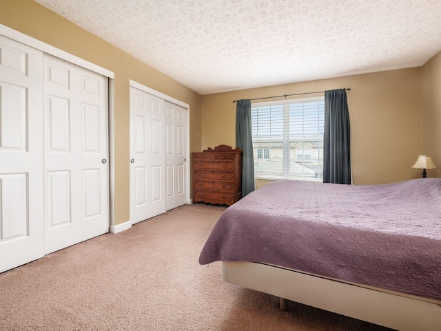 5678 Mango Ln Unit 104A, Hilliard, OH 43026 - carpeted bedroom featuring multiple closets and a textured ceiling